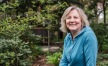 a person standing in a garden and smiling